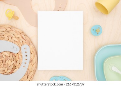 Baby Accessories And Tableware For Food On Wooden Background. Blank Greeting Card, Invitation Mockup. Flat Lay, Top View. Copy Space. Canvas Mock Up. Modern Minimal Template. Soft Shadow. Child Birth.