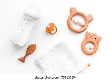 Baby Accessories. Wooden Toys, Pacifier And Bottle On White Background Top View