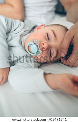 Baby asleep while parents caress