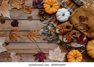 Baby Autumn Wear Clothes With Pumpkins And Leaves On Brown Background. Top View. Cute Warm Kid Autumn Bodysuit And Booties. Autumn Baby Shower