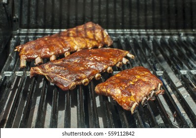 Baby Back Ribs Cooking On The Barbecue Grill
