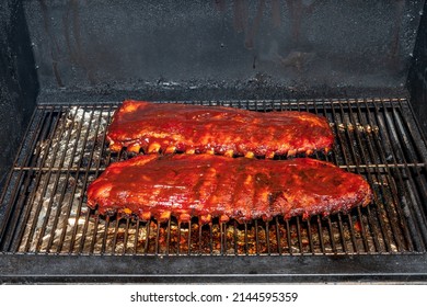 Baby Back Ribs Covered In Bbq Sauce On A Pellet Smoker