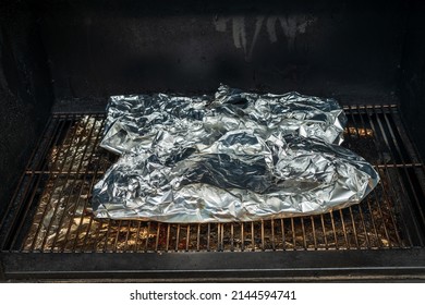 Baby Back Ribs Wrapped In Aluminum Foil On A Pellet Smoker