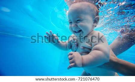 Baby background. Happy infant learn to swim, dive underwater with fun in pool to keep fit. Diving.
