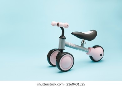 Baby Balance Bike Isolated on blue background. Modern Kids Three Wheels Tricycle Bicycle Side View.  - Powered by Shutterstock