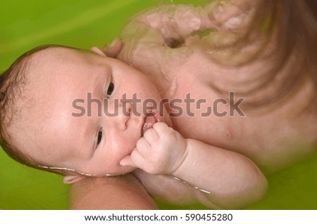 Image, Stock Photo Newborn in the bathtub held by her mother