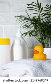 Baby Bath Accessories, Towel, Yellow Rubber Duck And Shampoo Bottles. The Concept Of Child Care.