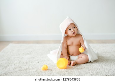 Baby in a bath towel with rubber ducks