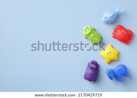 Baby bath toys on blue background. Flat lay, top view.