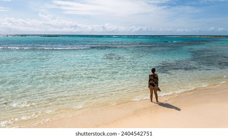 Baby Beach Aruba, Latina woman on the beach. Perfect beach, great for snorkeling, with calm waters, transparent in the Caribbean Sea with tricky blue waters. Great beach for children. 