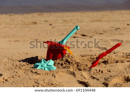 Similar – Sandstrand mit Spiezeugschaufel und Seestern