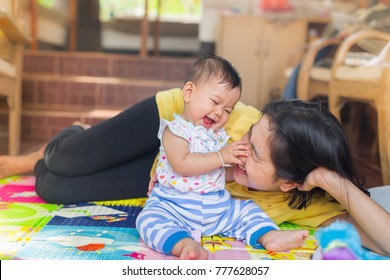 baby is being carried by mother.mother loves her daughter.she is always happy when they play together.