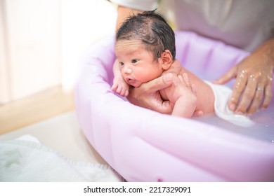 Baby being washed face down during bath - Shutterstock ID 2217329091