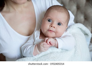 A baby with big eyes. Daughter in mom's arms
