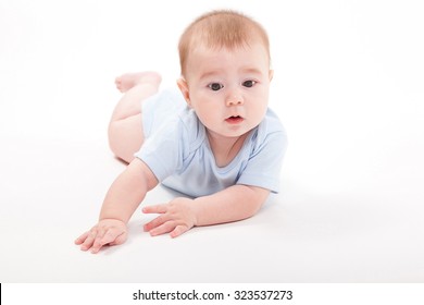 baby in the body lying on his stomach on a white background and looking at the camera, picture with depth of field