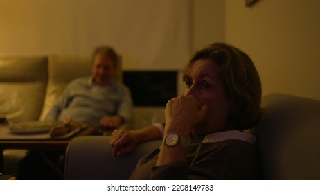 Baby Boomer Generation Watching Television At Living Room. Older Senior People Sitting On Couch Sofa