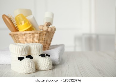 Baby booties and accessories on white wooden table indoors. Space for text - Shutterstock ID 1988323976