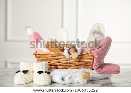 Baby booties and accessories on white marble table indoors