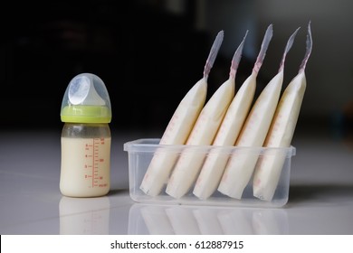 Baby Bottle With Milk And Frozen Breastmilk In Storage Bags