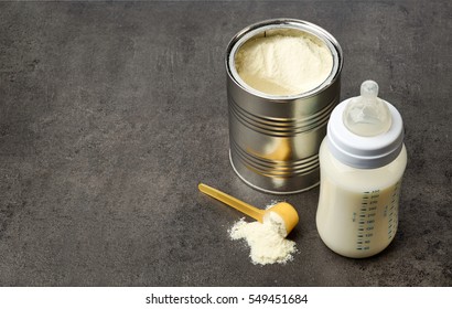 Baby Bottle And Milk Powder On Dark Grey Table