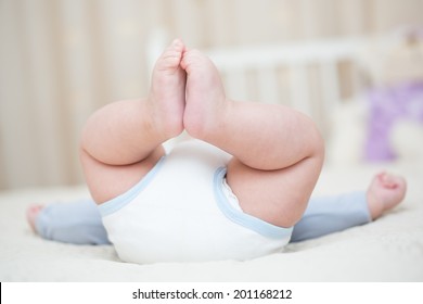Baby Bottom With Feet In The Air Sitting On The Bed