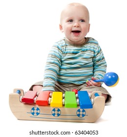 A Baby Boy With A Big Dribble Playing With A Rattle And A Xylophone.  Isolated On White.