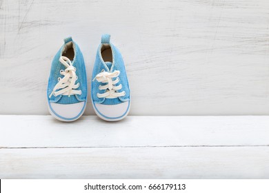 baby boy blue sneakers on white  wooden background
