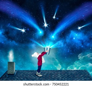 Baby boy in Christmas night is on the roof of the house and gathers the stars in a bucket.Star fall.