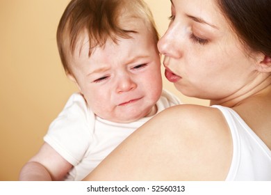baby boy crying in mothers arm; closeup faces