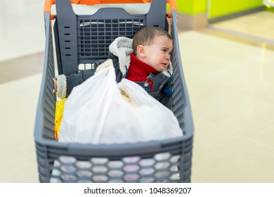 Baby Boy Crying In A Supermarket In A Cart. The Forgotten Child