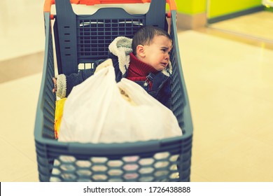 Baby Boy Crying In A Supermarket In A Cart. The Forgotten Child. Toned