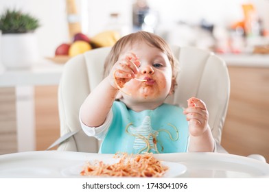 Baby boy eatig his dinner and making a mess