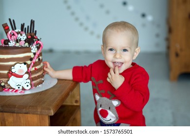 
Baby Boy Eating Christmas Cake And Smiling