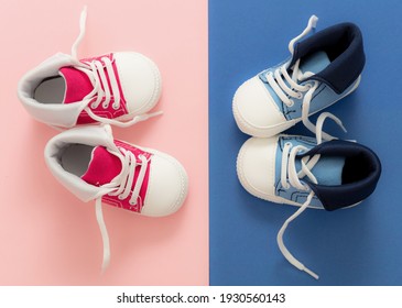 Baby Boy And Girl Sport Shoes On Pastel Pink And Blue Colors Background. Red And Blue Kids Small Size Sneakers, Canvas Booties Top View