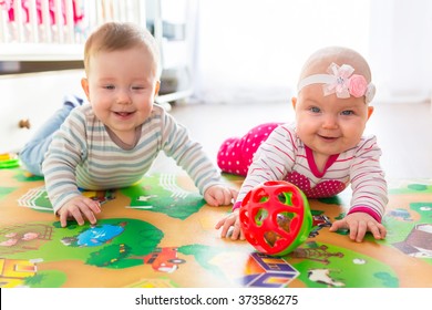 Baby Boy And Girl Twins Playing With The Ball At Home