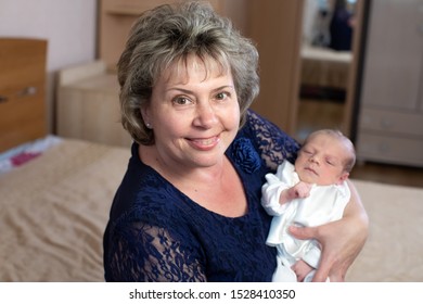 Baby boy in grandmother's arms in the room