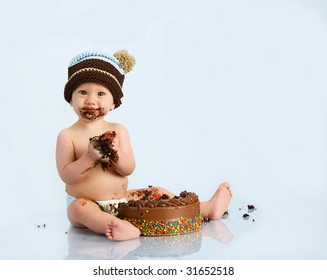 baby boy with hat and cake