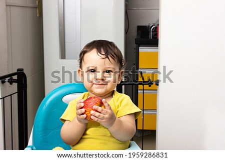 Baby Boy holding an apple while smiling to the camera - BLW healthy eating
