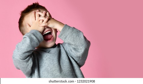 Baby Boy Kid Covering Close His Eyes With Hands And Palms Screaming Laughing  Over Pink Background