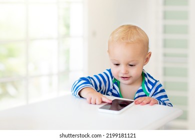 Baby Boy With Mobile Phone. Little Child Trying To Play With Cell Phone. First Educational Game Apps For Toddler. Infant And Technology. Kid Playing With Telephone.