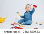 Baby boy on a white background plays with a plastic hammer. Children