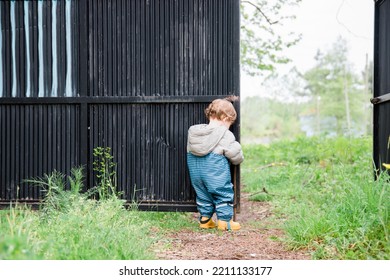 A Baby Boy Is Opening Garden Door, He Is Wearing Gardening Jump Suit. Background Is Pure Natural Green (no Face- Back Side Of The Baby Boy)