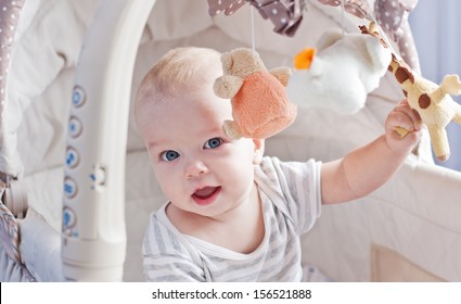 Baby Boy Playing Sitting In The Cradle With Mobile Toy Giraffe