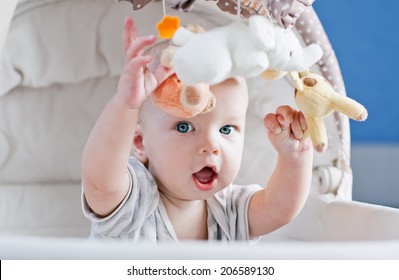 Baby Boy Playing Sitting In The Cradle With Mobile Toy 