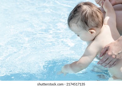 Baby Boy Playing In Water Pool For Kids.cute Hands Hit The Water, Splashing The Face.smiling Toddler With Tongue Out.mother Holds Baby Prevent From Falling.family Trip,vacation.