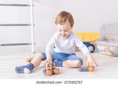 Baby Boy Playing With Wooden Toys At Home On The Floor