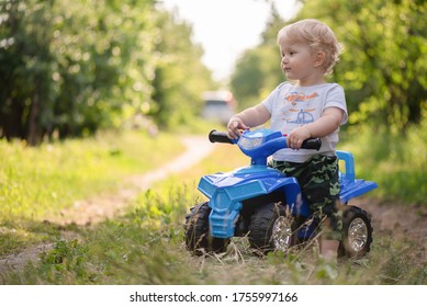 Baby Boy Is Riding A Toy Car Quad Bike.