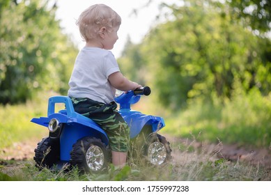 Baby Boy Is Riding A Toy Car Quad Bike.