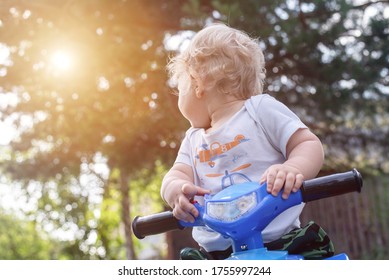 Baby Boy Is Riding A Toy Car Quad Bike.