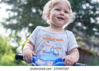 Baby Boy Is Riding A Toy Car Quad Bike.